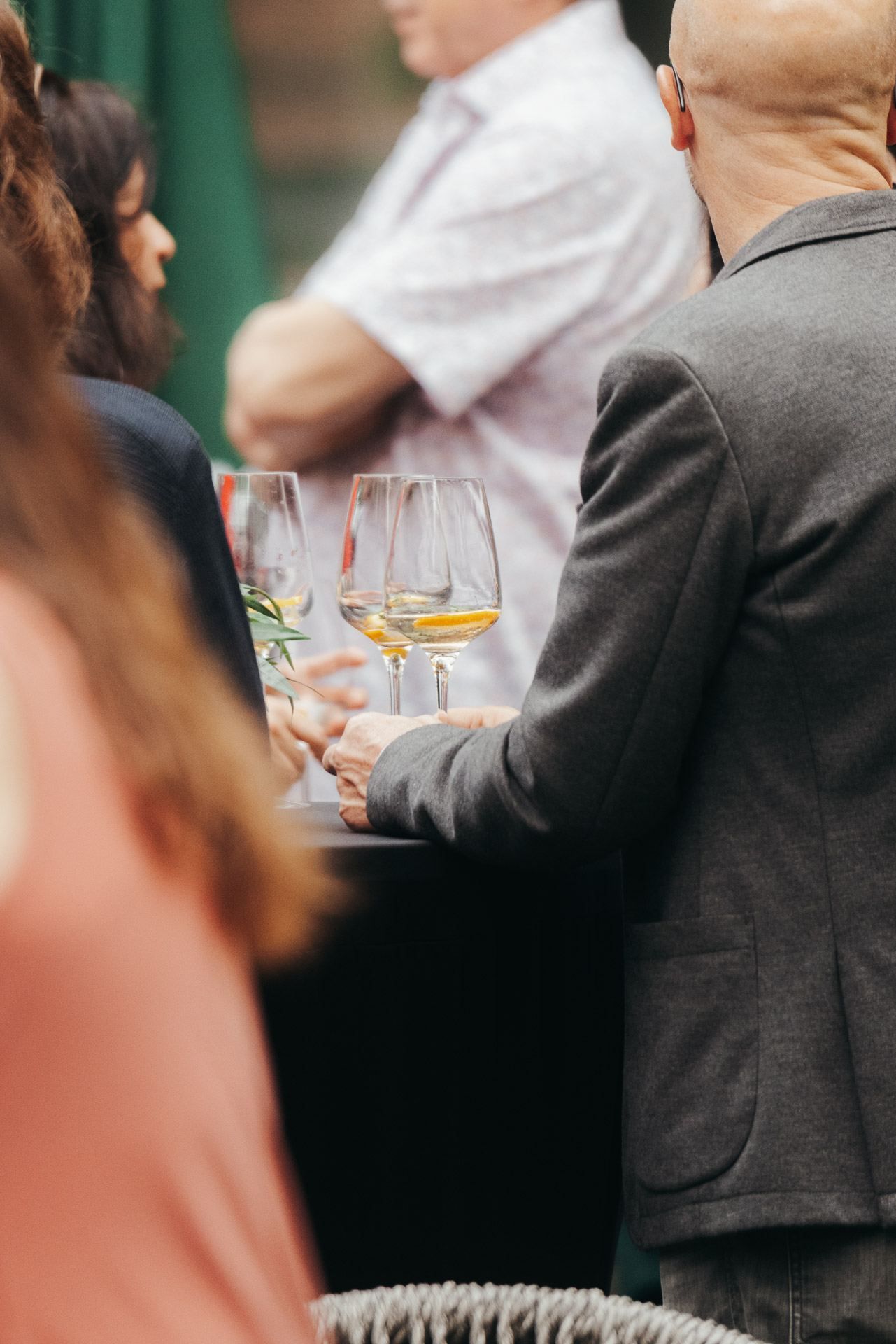 Gäste stoßen bei einer Feier im zwölf87 mit Weißwein an