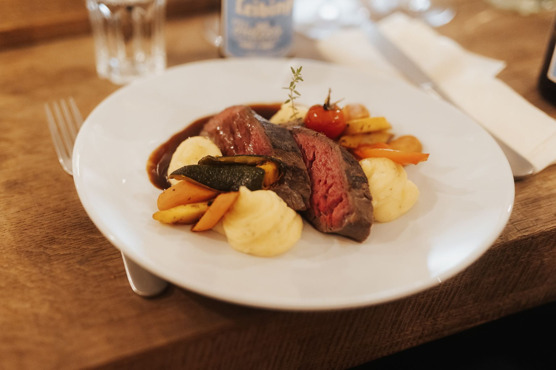 Medium-rare beef with mashed potato and vegetables, plated in our kitchen