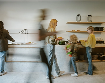 Frühstücksbuffet im Hotel zwölf87 – Traumwerk in Ravensburg mit einer Familie, die sich am Buffet bedient